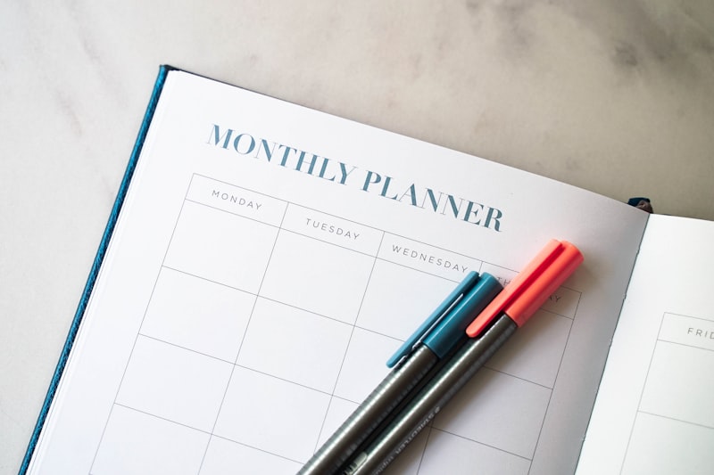 Notebook de agenda aberto em mesa de trabalho com caneta e planner