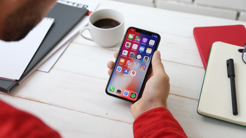 Smartphone com aplicativo de mensagens aberto sobre mesa de trabalho